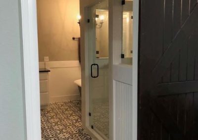 huddlestom-custom-floorplan-4055-4bed-3bath-bathroom-door-Texas-Barndominium-Photo